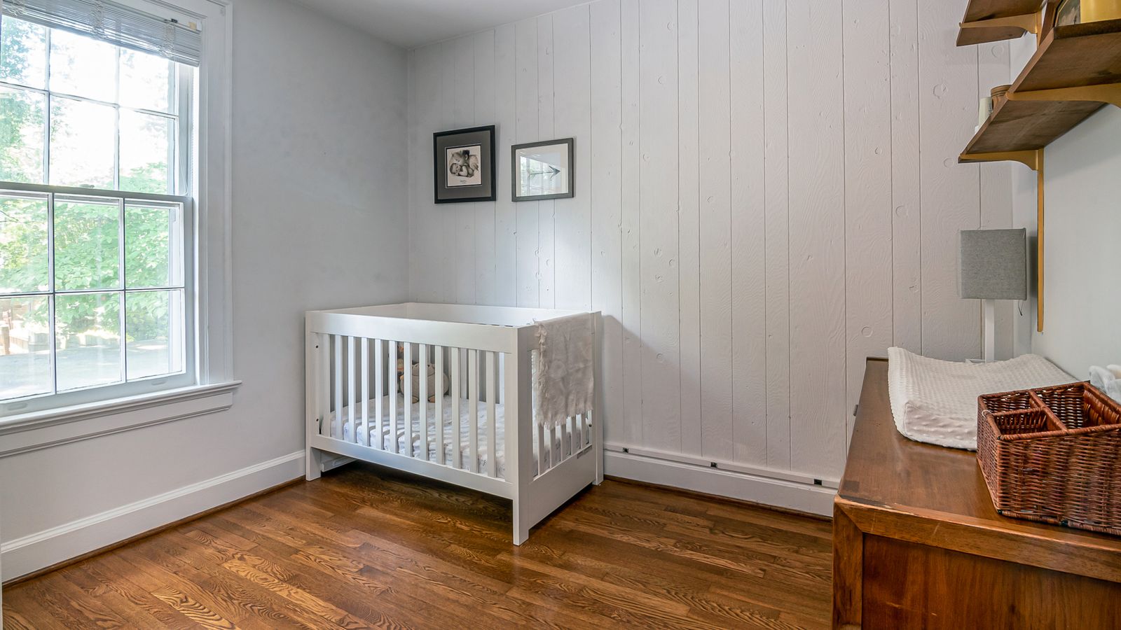 Petite chambre de bébé lumineuse avec murs clairs et berceau blanc