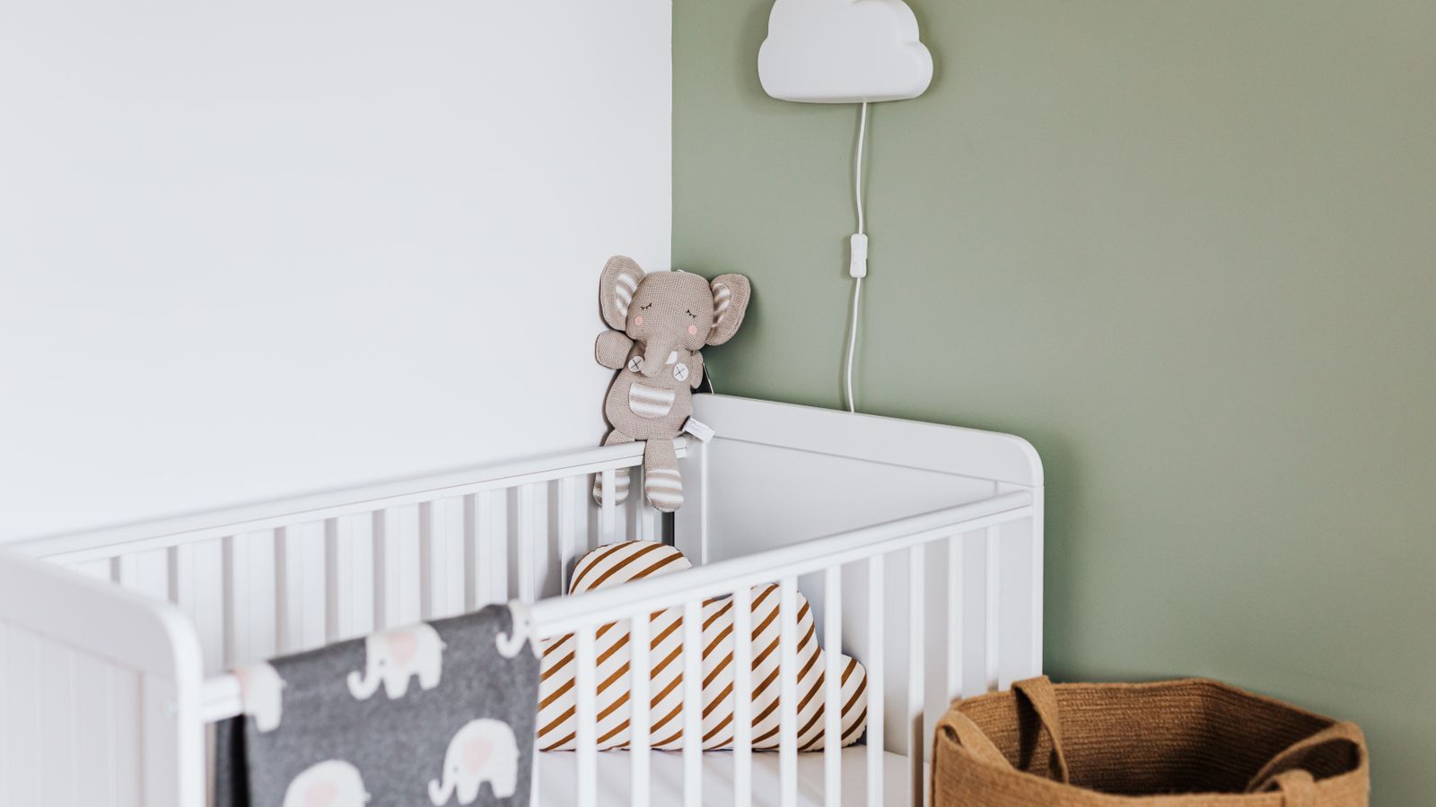 Chambre de bébé avec mur d'accent vert sauge et berceau blanc moderne