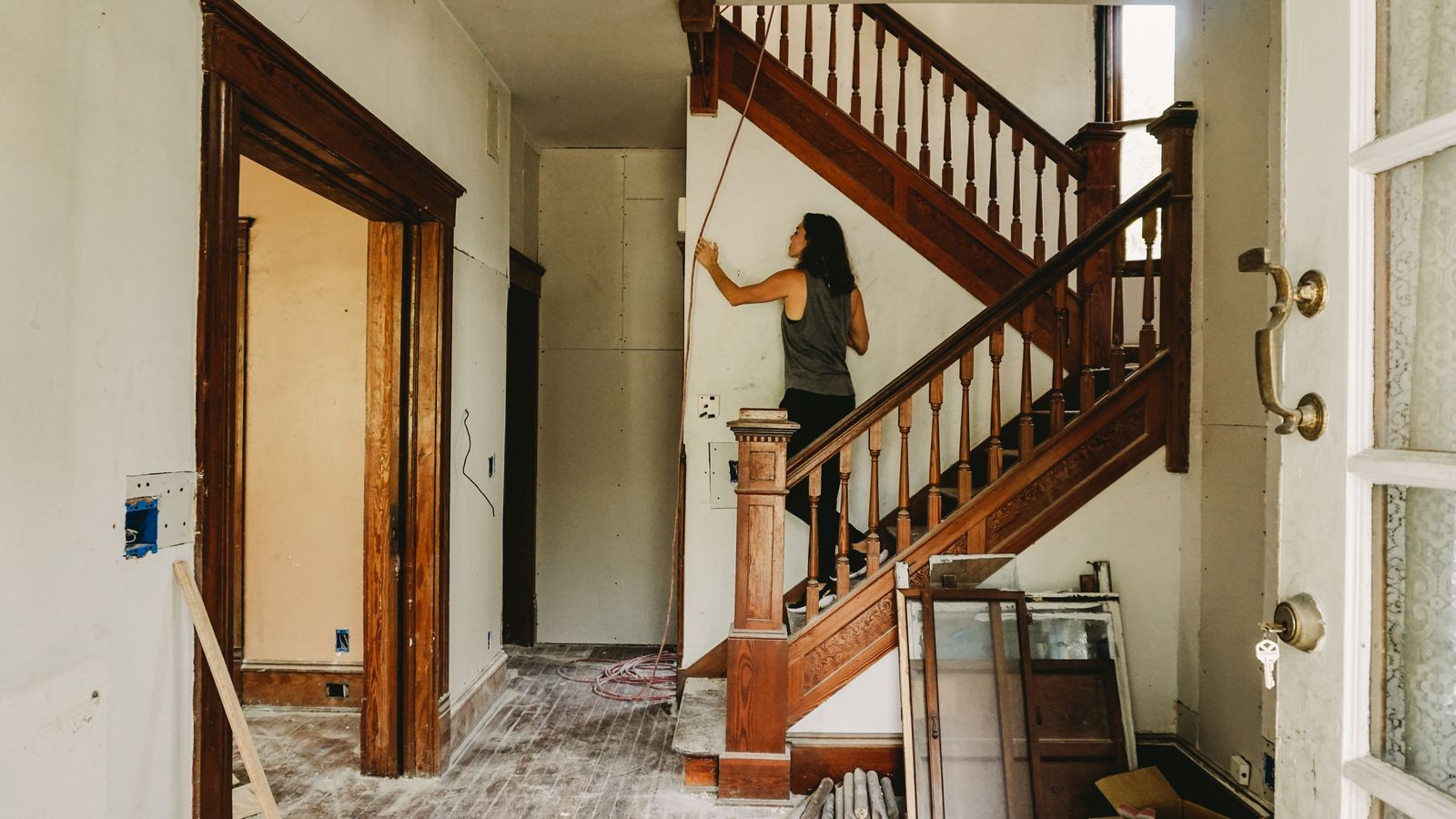 Femme en train de rénover et peindre un escalier en bois