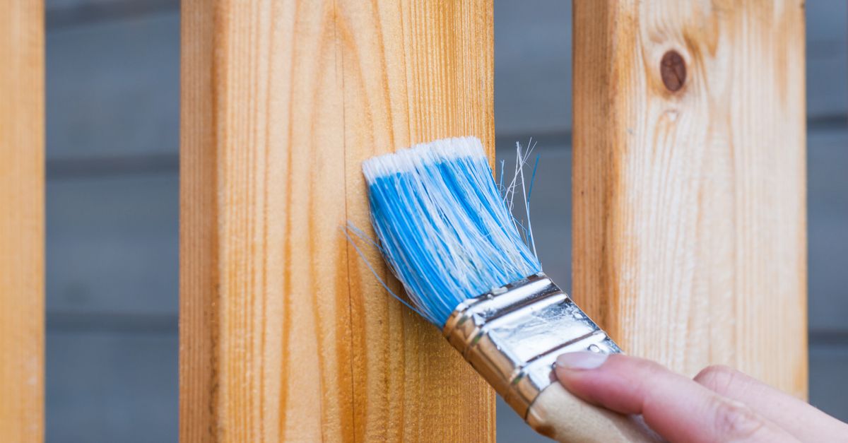 Application de peinture au pinceau plat sur une clôture en bois extérieure
