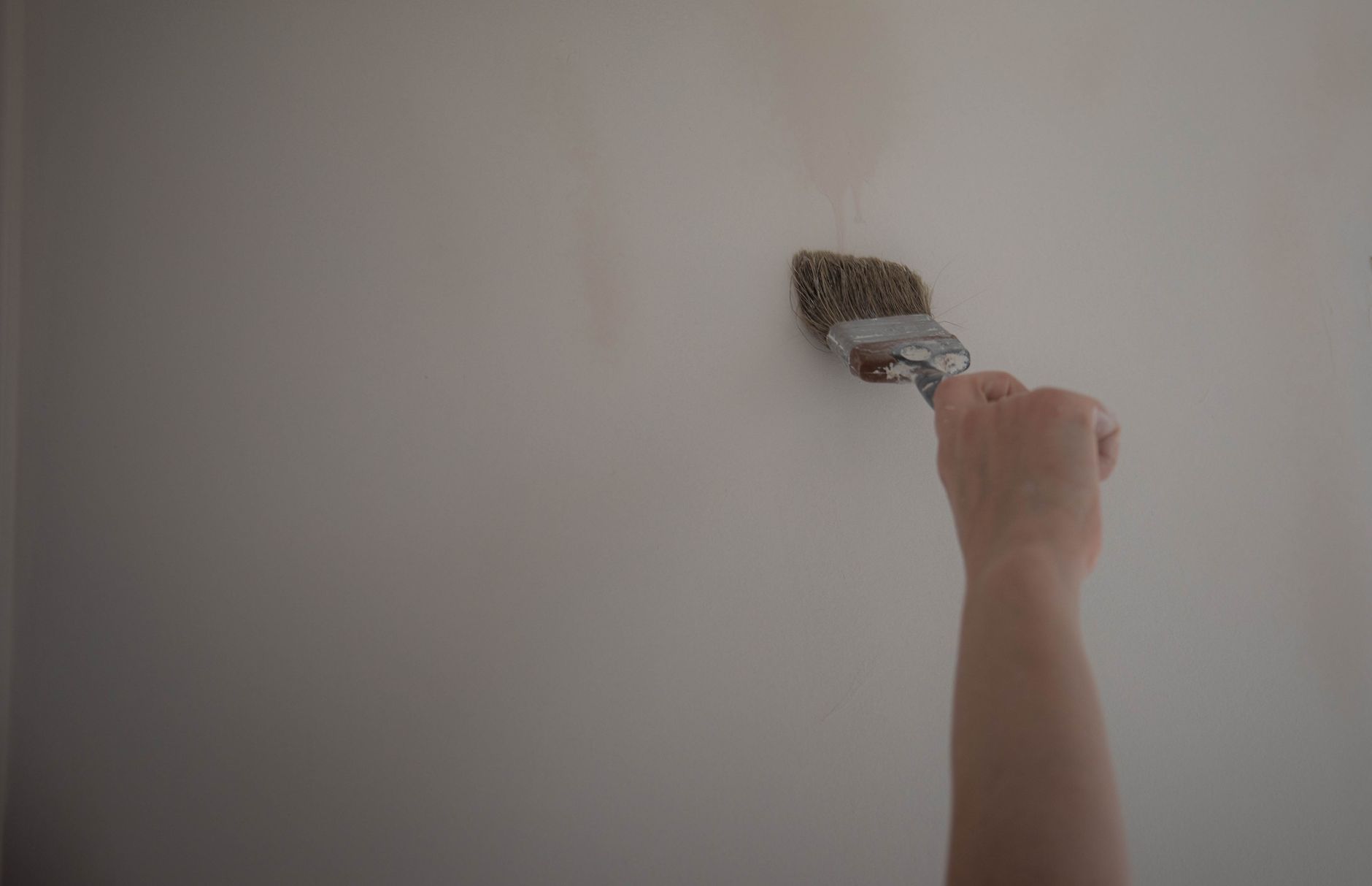 Application de peinture au pinceau sur un mur blanc – technique de peinture murale intérieure