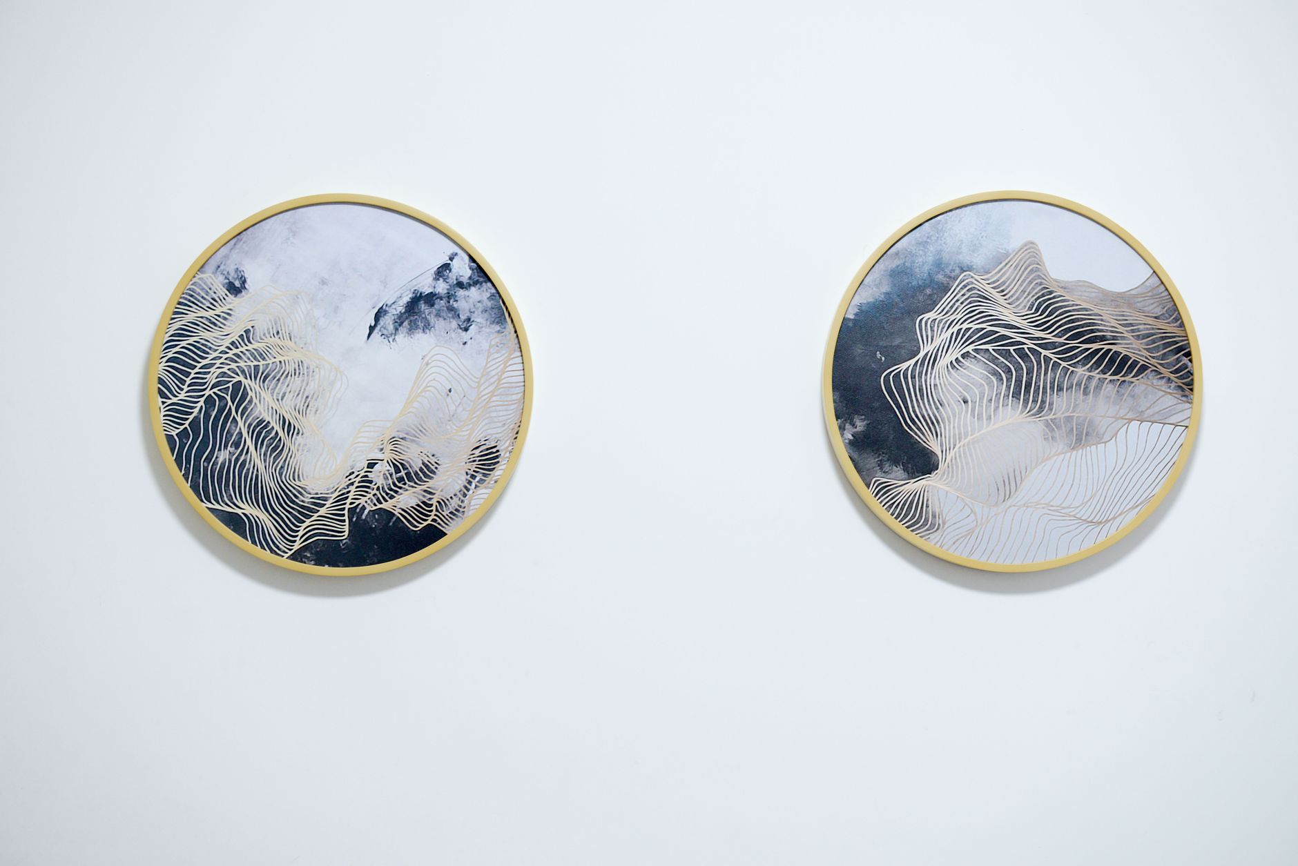 Deux tableaux ronds à cadre doré sur mur blanc peint – exemple de décoration murale sobre