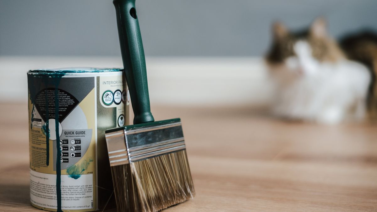 Pinceau et pot de peinture pour l'application sur parquet en bois