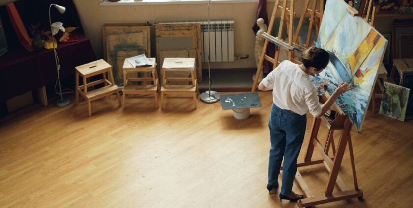 Femme peignant à l'acrylique sur une toile dans un atelier lumineux