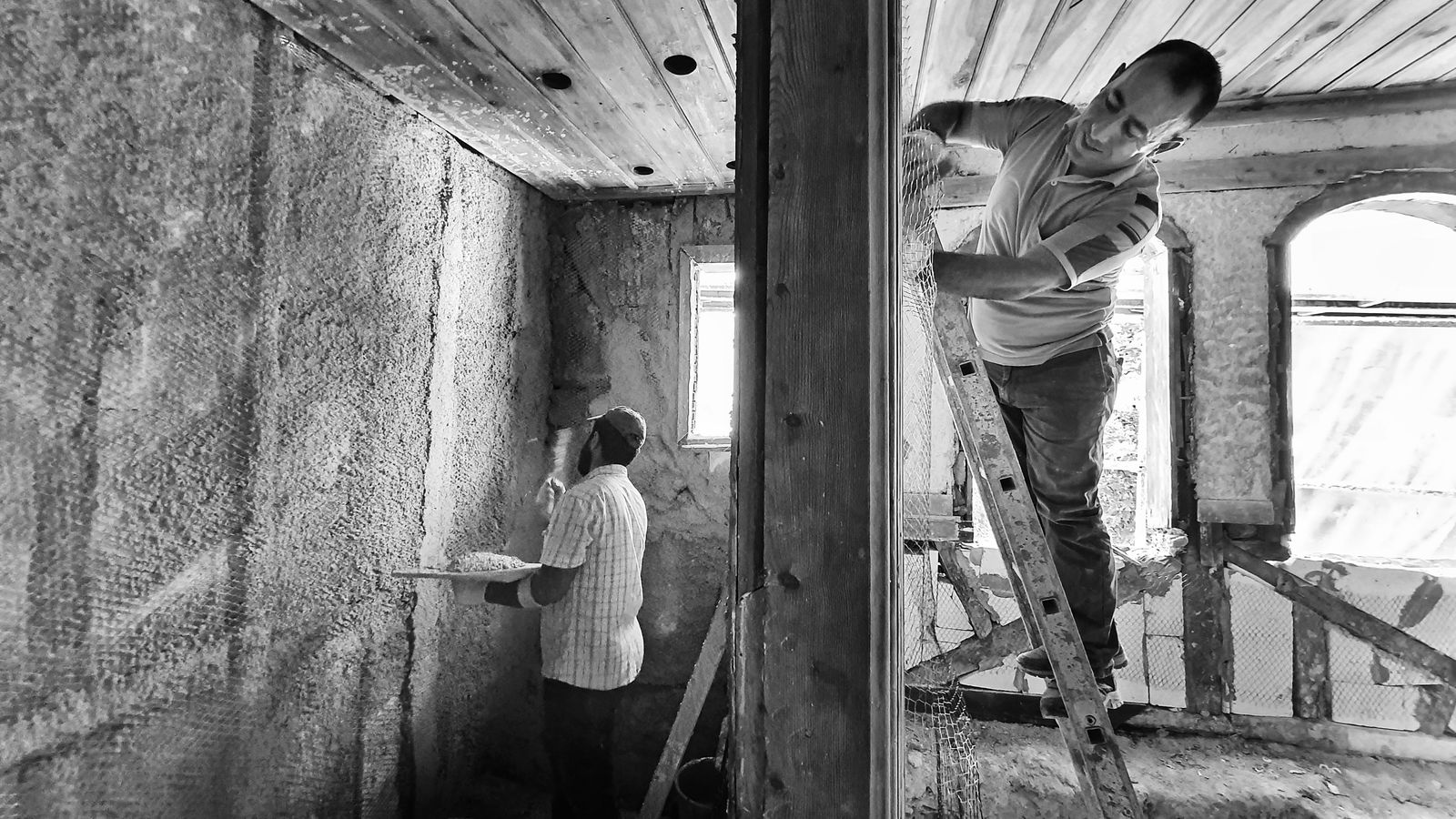 Artisans réalisant des travaux d'isolation thermique par l'extérieur sur une maison
