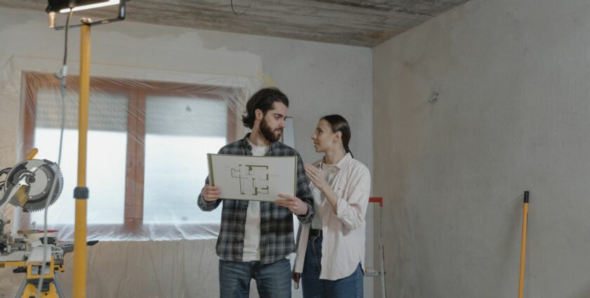 Couple planifiant leur rénovation énergétique avec plans architecturaux