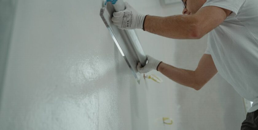 Application d'enduit de lissage sur un mur intérieur avec une taloche