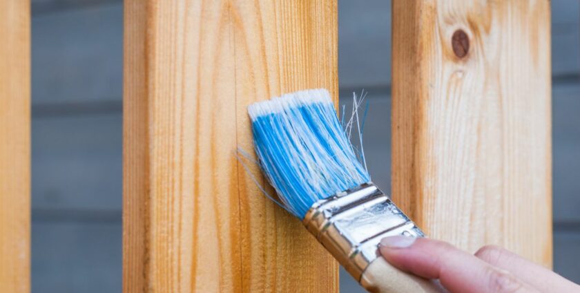 Application de peinture avec un pinceau sur des plinthes en bois